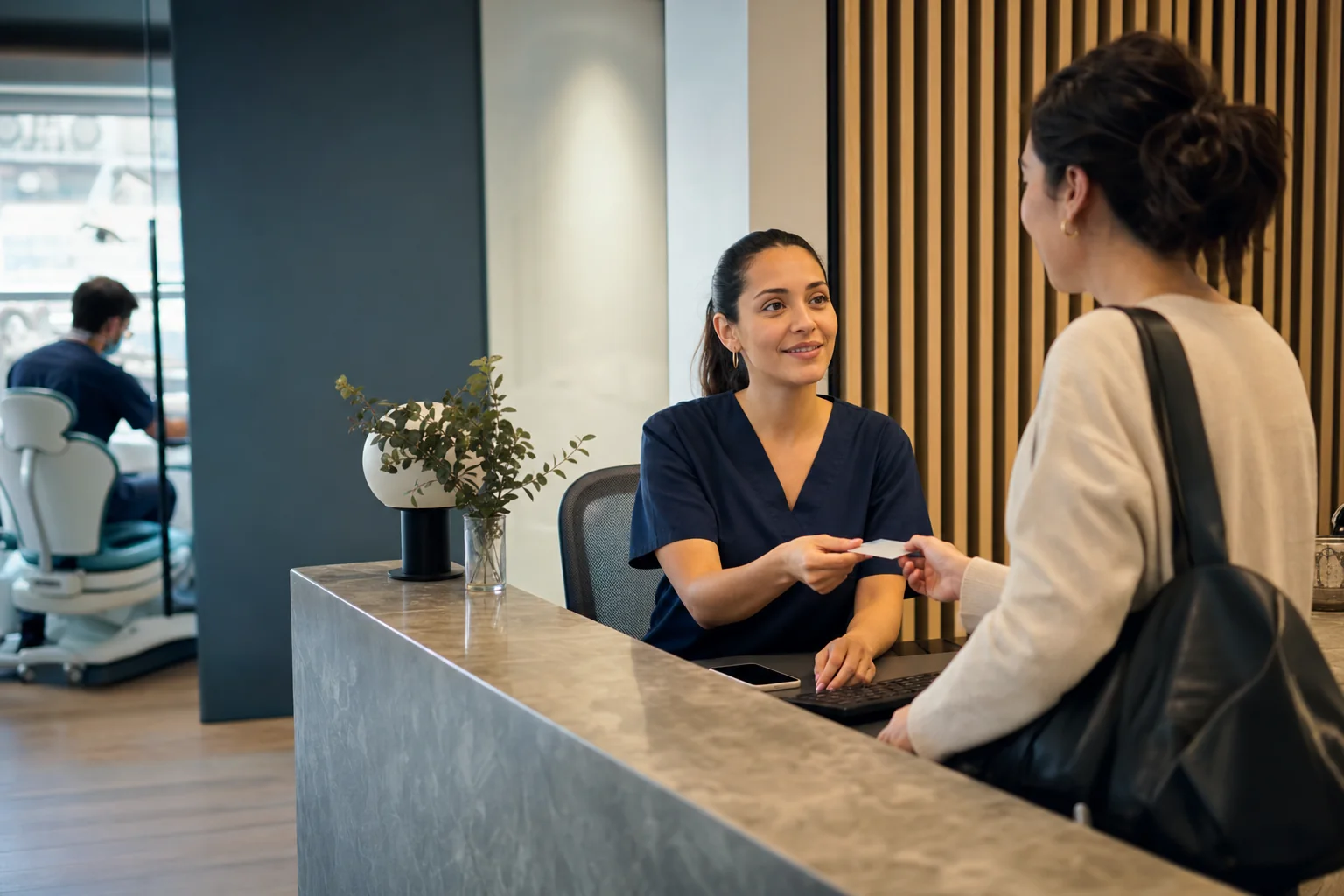 Recepcionista atendiendo a una paciente en un consultorio odontológico